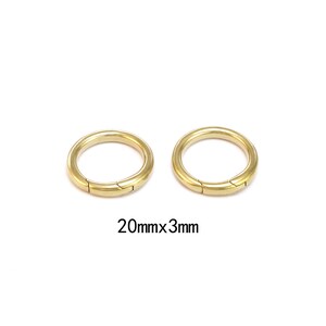 Pode incluir: Dois an&eacute;is de metal dourado com fecho articulado. Os an&eacute;is t&ecirc;m 20 mm de di&acirc;metro e 3 mm de espessura. Fundo branco.