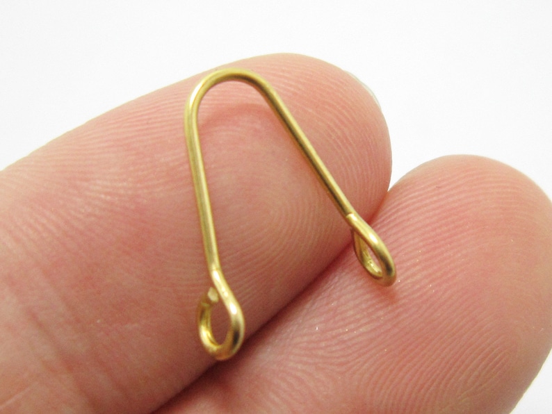 May include: Gold-toned metal jewelry finding with a loop on each end. The finding is shaped like an upside-down U.