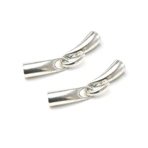 May include: Two silver metal end caps for jewelry making. Each end cap has a curved shape and a small loop for attaching to a chain or cord.