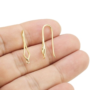May include: Three gold earring hooks, two are simple and one has a diamond shape at the top.