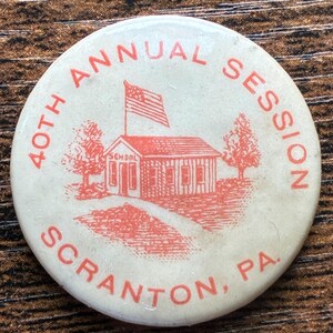 May include: A round, off-white button with red text and graphics. The text reads "40th Annual Session Scranton, PA." A red illustration depicts a schoolhouse with an American flag.