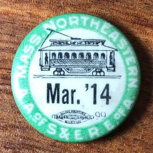 May include: Green and white button with the text "Mass. Northeastern A. of S. & E. R. of A." and a black and white illustration of a streetcar. The button also has the text "Mar. '14" and "Allied Painting Trades Union Council 99 Boston".