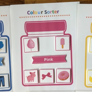 Può includere: Un'attività di ordinamento dei colori stampabile per bambini. L'immagine mostra un barattolo rosa con la parola "Rosa" e immagini di zucchero filato, un ghiacciolo, un maiale, un fiocco e una ciambella.
