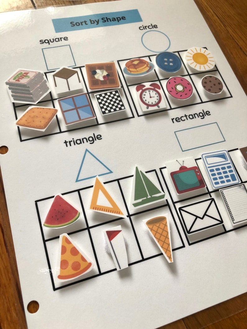May include: A white worksheet with the title "Sort by Shape" and images of various shapes, including circles, squares, rectangles, and triangles. The images include a pizza, a watermelon, a waffle, a clock, a donut, a sun, a sailboat, a window, a table, a cracker, a cookie, a flag, a ruler, a calculator, a TV, an envelope, a notepad, and a cone.