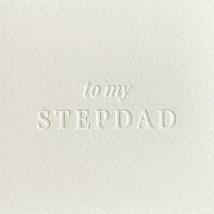 May include: A white card with the text "to my STEPDAD" in a raised, embossed font.