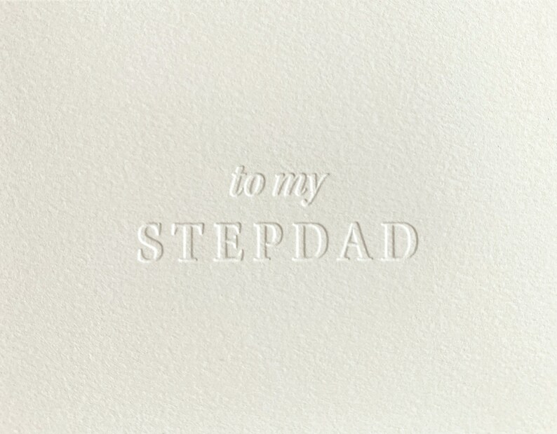 May include: A white card with the text "to my STEPDAD" in a raised, embossed font.