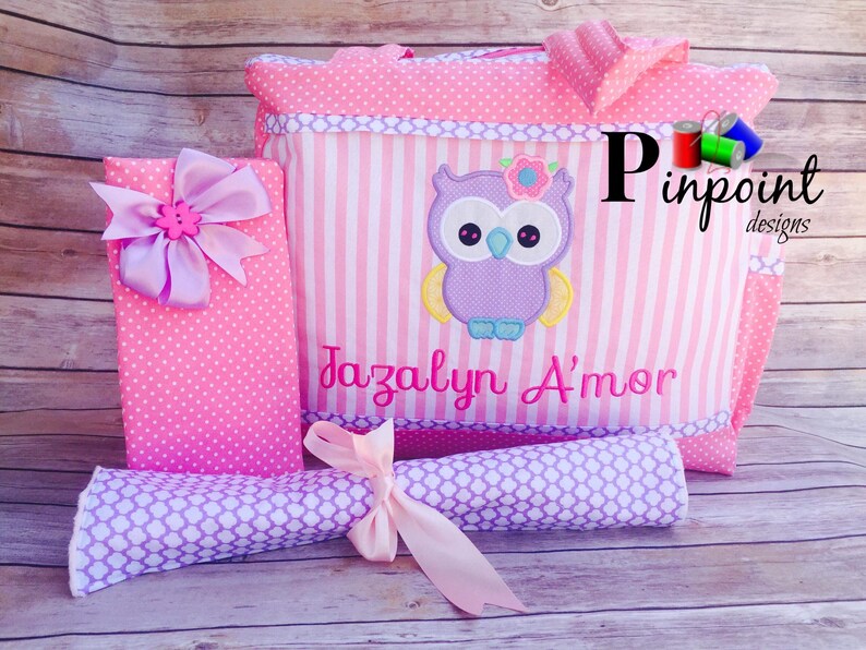 Puede incluir: Bolso de mano rosa y morado con un b&uacute;ho morado y el nombre Jazalyn A'mor bordado. El bolso forma parte de un conjunto que incluye una caja a juego de lunares rosa y blancos y un rollo de patr&oacute;n morado y blanco.