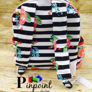 May include: Black and white striped backpack with a floral print. The backpack has a white zipper and white straps. The text "Pinpoint Designs" is visible at the bottom of the image.