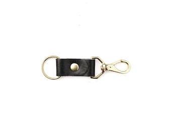 May include: A black leather key chain with a gold metal ring and a gold metal clip.