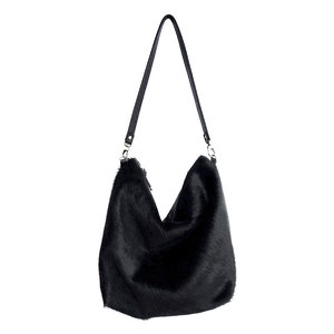 Puede incluir: Un bolso de mano de piel sint&eacute;tica negra con una larga correa de cuero negro.