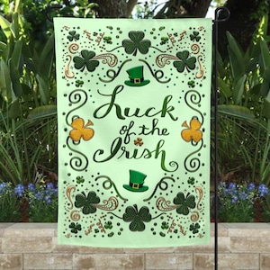 May include: A green garden flag with a white background and gold accents. The flag features a shamrock design and the text "Luck of the Irish".