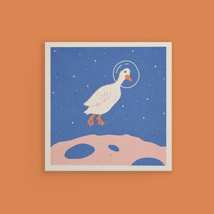 K&ouml;nnte beinhalten: Eine wei&szlig;e Ente mit einem Raumfahrthelm steht auf einer rosafarbenen und blauen mondartigen Oberfl&auml;che mit einem sternen&uuml;bers&auml;ten blauen Hintergrund.