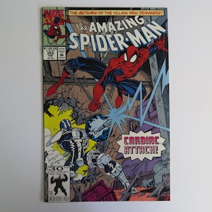 May include: A comic book cover featuring Spider-Man in a red and blue suit, swinging through a city scene. The cover text reads "The Amazing Spider-Man" and "Cardiac Attack!" The cover also features a 30th anniversary logo.