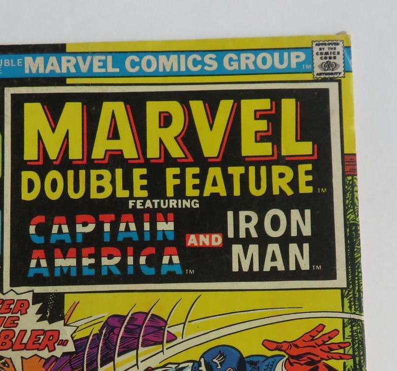 Puede incluir: Una portada de c&oacute;mic vintage de Marvel Comics de doble edici&oacute;n con Captain America y Iron Man. La portada es amarilla con detalles en rojo, blanco y azul. El t&iacute;tulo "Marvel Double Feature" est&aacute; en letras amarillas con contornos rojos. Las palabras "Captain America" e "Iron Man" est&aacute;n en letras rojas, blancas y azules.