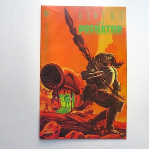 May include: Comic book cover featuring a Predator wielding a weapon, set against an orange and red background. The title "ALIENS vs. PREDATOR" is in green. The artwork depicts a sci-fi battle scene with a spaceship and alien figures.