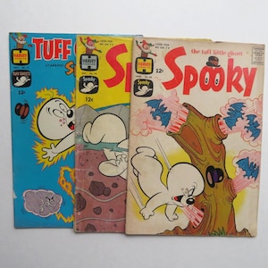 May include: Three vintage Harvey Comics comic books featuring the characters Tuff Ghosts and Spooky. The comic book covers are in blue, yellow, and red, with illustrations of ghosts and bats. Each comic book is marked with the price of 12 cents.