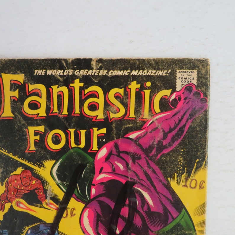 Pu&ograve; includere: Una copertina di fumetto vintage con i Fantastici Quattro. La copertina &egrave; nera con lettere gialle e un'illustrazione viola e verde di un supereroe.