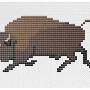 May include: A brown and black pixelated image of a bison, a large, shaggy, wild mammal with horns.
