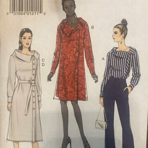 May include: Vogue Patterns sewing pattern for a dress and pants. The dress pattern is for a long-sleeved, collared dress with a button-up front and a belt. The pants pattern is for a pair of wide-leg pants with a button-up front. The pattern is for sizes 6-8-10-12-14.