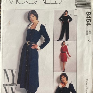 May include: McCall's sewing pattern number 8454 size 6. The pattern includes instructions for making a dress with a white collar and a skirt with buttons down the front. The pattern also includes instructions for making a pair of pants.