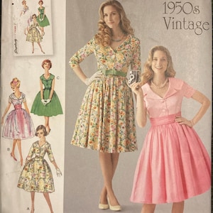 May include: A Simplicity 1459 sewing pattern envelope for 1950s vintage style dresses. The cover features illustrations and photographs of dresses with collars, button-front bodices, and full skirts in floral and solid pink fabric designs.