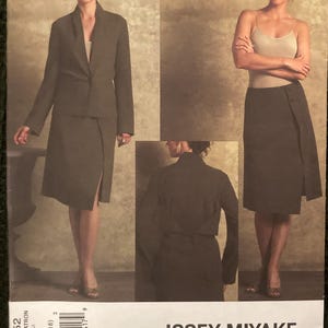 May include: A Vogue designer original sewing pattern by Issey Miyake, V2952. The pattern features a skirt and jacket ensemble. The image shows the finished garments in a dark olive green color. The pattern size is D (12-14-16).