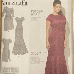 May include: Simplicity Amazing Fit dress pattern. The pattern features a two-piece raglan sleeve and princess seams. The image shows a woman wearing a burgundy dress. The pattern includes sizes 20W-28W.