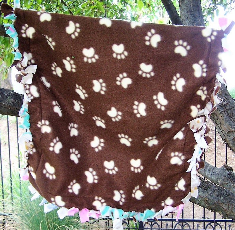 The background is creme with multi-colored cats Small Cat Throw in 100/% Glacier poly fleece What a fun cat throw! Size is 24x 24.