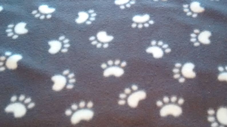 The background is creme with multi-colored cats Small Cat Throw in 100/% Glacier poly fleece What a fun cat throw! Size is 24x 24.