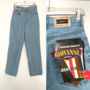 May include: Light blue denim jeans with a high waist and straight leg. The jeans have a label on the back pocket that reads "Standard Quality Giovanni Collection Jeans Wear Basic & Beyond Since 1980".