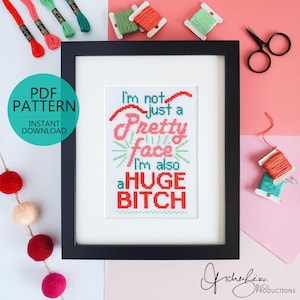 以下が含まれることがあります： 「I'm not just a pretty face, I'm also a HUGE BITCH」の文字が入った額入りのクロスステッチアート。画像には糸巻き、ハサミ、PDFパターンのダウンロードグラフィックが含まれています。