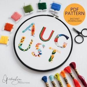 Könnte beinhalten: Ein Stickrahmen mit dem Wort "AUGUST", gestickt mit bunten Fäden. Die Buchstaben sind mit Bildern von Kajak, Wassermelone, Sonnenblumen, Eiscreme und Mais verziert. Ein gelber Kreis zeigt "PDF PATTERN" und "INSTANT DOWNLOAD".