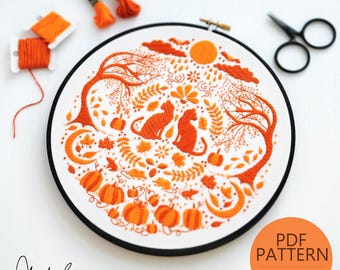 May include: A digital embroidery pattern featuring two cats sitting in a circle of autumn leaves, pumpkins, and other fall elements. The pattern is in orange and white and is perfect for a fall-themed embroidery project. The text "PDF PATTERN INSTANT DOWNLOAD" is at the bottom of the image.