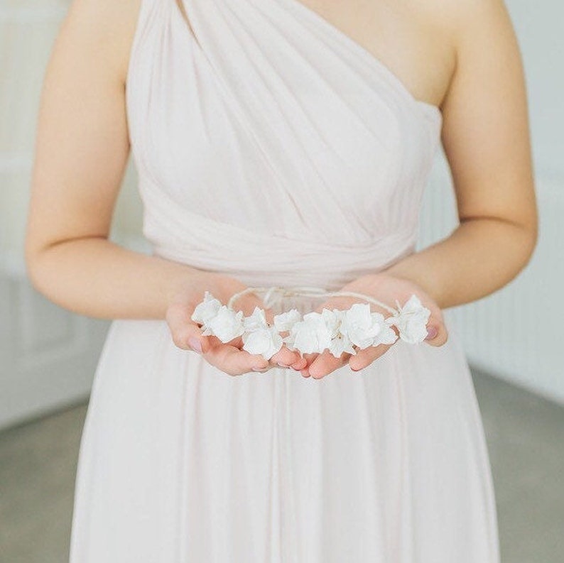 May include: A white flower crown with a simple design, made of delicate white flowers.