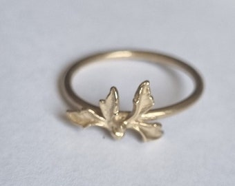 Puede incluir: Un anillo de oro con un delicado diseño de hojas. El anillo es simple y elegante, perfecto para el uso diario.