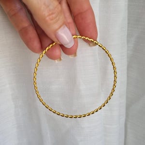 Puede incluir: Un brazalete de oro trenzado.