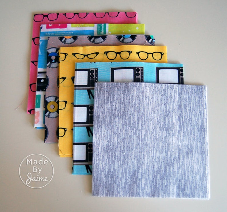 May include: Stack of fabric squares with various retro patterns, including records, eyeglasses, televisions, and a grey textured fabric square.