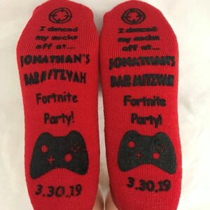 May include: Red socks with black text and a video game controller graphic. The text reads "I danced my socks off at... Jonathan's Bar Mitzvah Fortnite Party! 3.30.19"