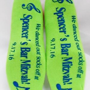 May include: A pair of green socks with blue text that reads "We danced our socks off at Spencer's Bar Mitzvah! 9.17.16" on each sock.