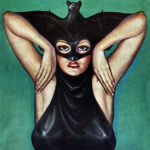 Könnte beinhalten: Eine Frau in einem schwarzen, fledermausförmigen Kostüm mit einer Fledermaus, die obenauf sitzt. Sie trägt eine schwarze Maske über den Augen und roten Lippenstift. Der Hintergrund ist einfarbig grün.