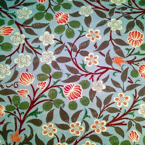 Könnte beinhalten: Ein sich wiederholendes Muster aus stilisierten Blumen und Blättern in Rot-, Orange-, Weiß-, Grün- und Brauntönen auf hellblauem Hintergrund.