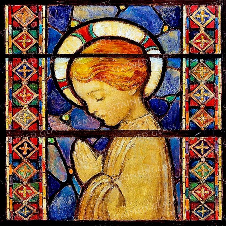 May include: A stained glass window featuring a young person with red hair, wearing a white robe, praying with hands clasped. The figure is surrounded by a blue halo with red and green accents. The window is framed by a border of colourful geometric shapes.