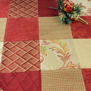May include: A red and gold patchwork Christmas tree skirt with a scalloped edge. The skirt is made of different fabrics with various patterns, including floral, plaid, and geometric designs.