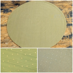 May include: Three green placemats with different patterns. The first placemat is a solid green with a subtle texture. The second placemat has a green and gold striped pattern with small gold dots. The third placemat has a green and gold diagonal striped pattern with small gold dots.