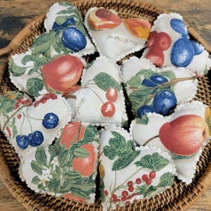 May include: A collection of ten heart-shaped fabric sachets with various fruit and floral designs. The sachets are filled with dried herbs and flowers, and are perfect for adding a touch of fragrance to any room.