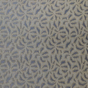 May include: A close-up of a fabric with a repeating pattern of gold leaves on a dark gray background.