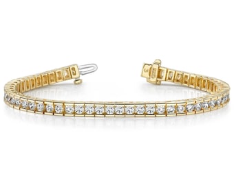 May include: A gold tennis bracelet with a row of round diamonds set in a pave setting.