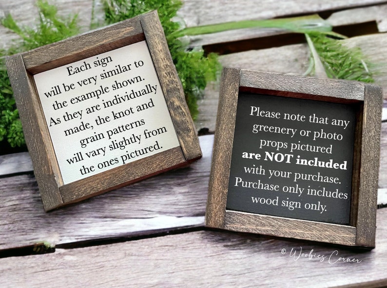 May include: Two wooden signs with black text on a white background. The sign on the left says "Each sign will be very similar to the example shown. As they are individually made, the knot and grain patterns will vary slightly from the ones pictured." The sign on the right says "Please note that any greenery or photo props pictured are NOT included with your purchase. Purchase only includes wood sign only."
