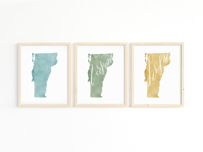 May include: Set of three framed art prints featuring the state of Vermont. Each print showcases a watercolor-style map of Vermont in shades of teal, green, and gold, with the words "Vermont" and "home" in cursive.