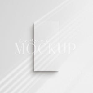 Puede incluir: Maqueta de lienzo blanco con el texto "canvas mockup" en blanco sobre un fondo blanco con sombras.